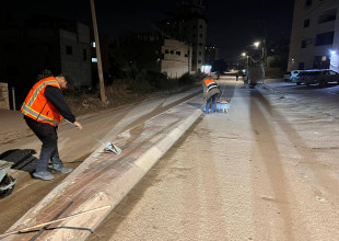 جانب من أعمال النظافة ودهان للجزر والأرصفة في شارع مدارس الإسراء